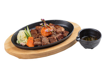 Isolated medium rare wagyu steak topping with mince carrot on hot plate and wooden plate served with potato salad with ponzu sauce.