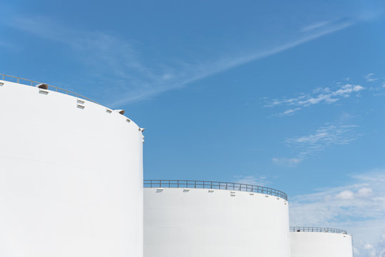 Oil Tanks In A Row Under Blue Sky In Pasadena, Texas, USA. Large White Industrial Tank For Petrol, Oil, Natural Gas Storage. Tank Farm At Petrochemical, Oil Refinery Plant. Energy And Power Background