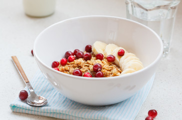 Muesli with banana and berries for breakfast.