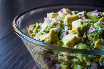 Avocado Salad with Red Onions in glass bowl.