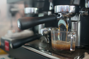 Close up barista hands making coffee by machine in coffee cafe.
