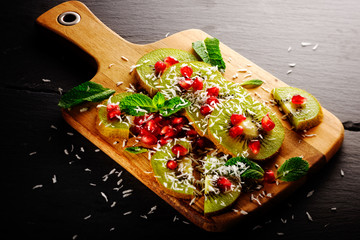 Kiwi mit granatapfel und kokosraspel