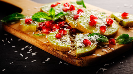 Kiwi mit granatapfel und kokosraspel