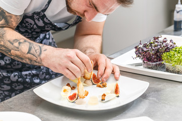 The chef is garnishing appetizer dish