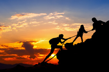 Silhouette of hikers climbing up on the mountain.