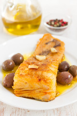 fried cod fish with garlic and olive oil on dish