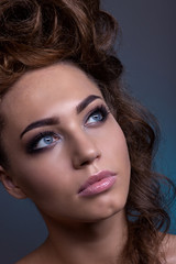 Portrait of a beautiful girl with a creative high hairstyle and makeup.