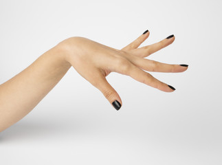 Female hand with black nails, isolated on white background. Shallow depth photography.