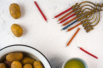 Frame of Hanukkah, olive oil and potatoes on a white background