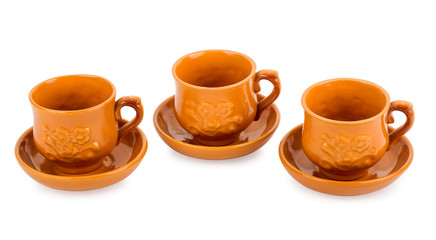 three clay teacups with saucers