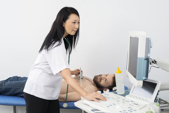 Doctor Using Ultrasound Machine While Examining Patient