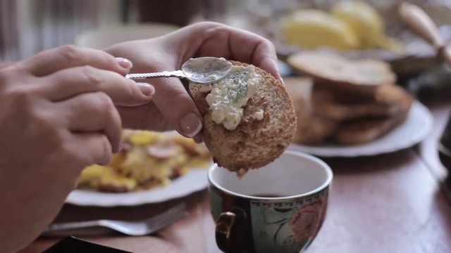 rural breakfast, woman smears a pate on a piece of bread