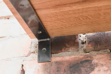 Shelf in wood and metal hanging on a brick wall in loft style