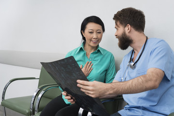 Doctor Showing X-ray To Happy Female Patient