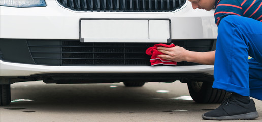 red rag wipe the car bumper after a car wash, close-up