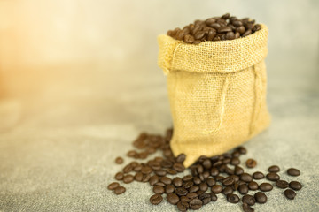 Fototapeta na wymiar coffee beans in bag on concrete background