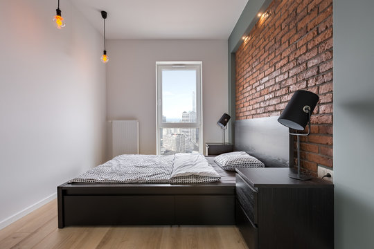 Stylish bedroom with brick wall