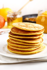 Stack of homemade pumpkin pancakes on white table
