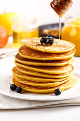 Stack of homemade pumpkin pancakes on white table