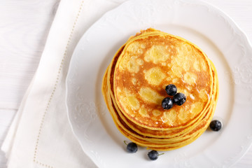 Stack of homemade pumpkin pancakes on white table