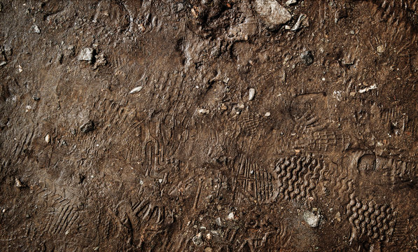 Wet ground with footprints. Mud ground with human footprints. Soil background