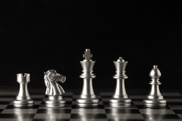 Chess on a chessboard at black background, Business leader concept.