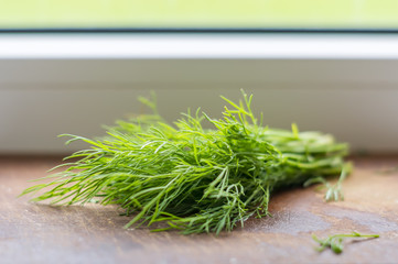 green dill on cutting desk, soft focus