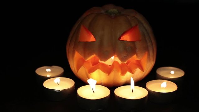 Halloween and All Saints Day. Scary pumpkin lantern. Pumpkin Jack, burning candles. 