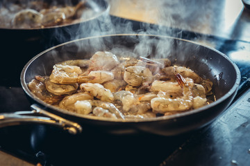 Preparing a seafood dish - shrimps fired in a pan