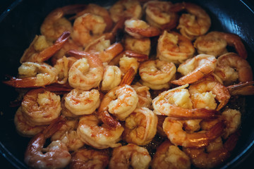 Preparing a seafood dish - shrimps fired in a pan