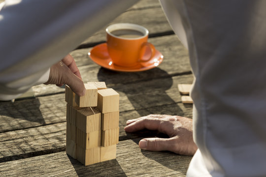 Man building a construction from toy blocks