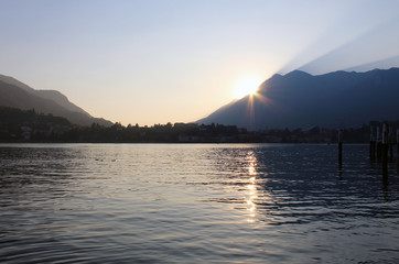 Sunset behind mountains with lake in an early autumn evening