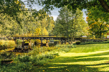Beautiful autumn view of a narrow river with crossing bridge in Ovansjö, Sweden