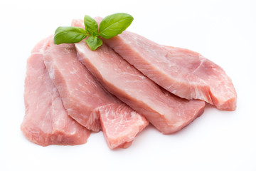 Fresh pork fillet with basil on a white background.