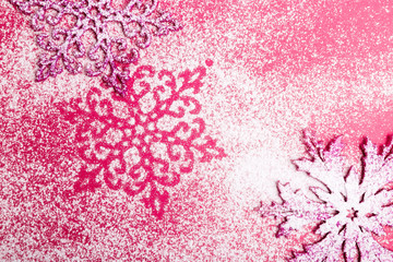 Pink and white snowflakes on a pink background. Christmas background. Top view. Copy space. Decorative snow.