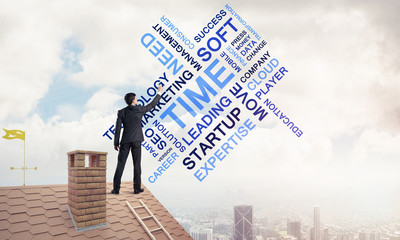 Young businessman standing on house roof and writing leadership 