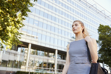 Businesswoman Walking Past Modern City Offices On Way To Work