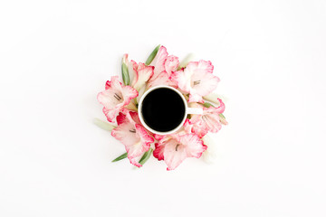 Beautiful pink gladiolus flower frame and coffee cup on white background. Flat lay, top view.