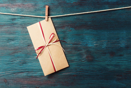 Greeting card in envelope over rustic wooden background