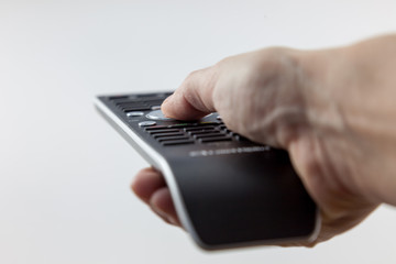 TV remote control in hand on white background
