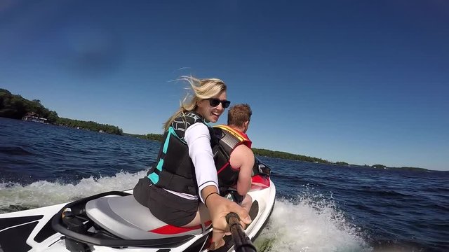 pretty girl having fun on back of seadoo selfie slow motion