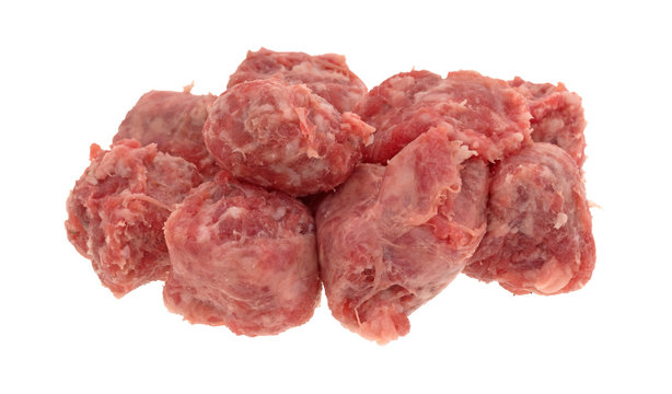 Several slices of raw mild bratwurst sausage isolated on a white background.