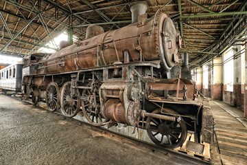 Fototapeta na wymiar Very rusty old steam engine in the historic depot