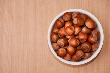 Nuts in a bowl on a wooden background, Brown nuts. Nuts. Top view.