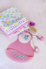 pink plastic baby bib ,hairbrush and diapers