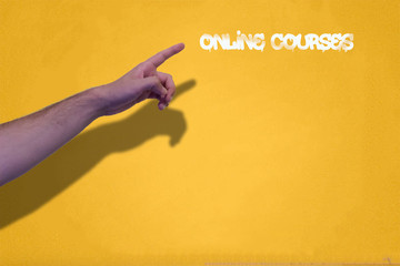 hand points online courses written on a yellow wall with yellow paint