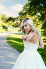 Fototapeta na wymiar blonde woman in tulle dress follow me in park path