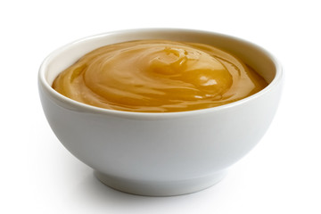 Lemon curd in white ceramic bowl isolated on white.