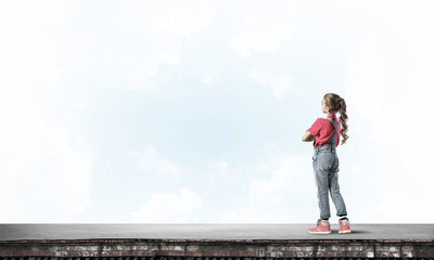Concept of careless happy childhood with girl looking far away