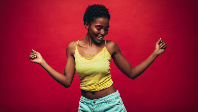 African woman dancing over red background